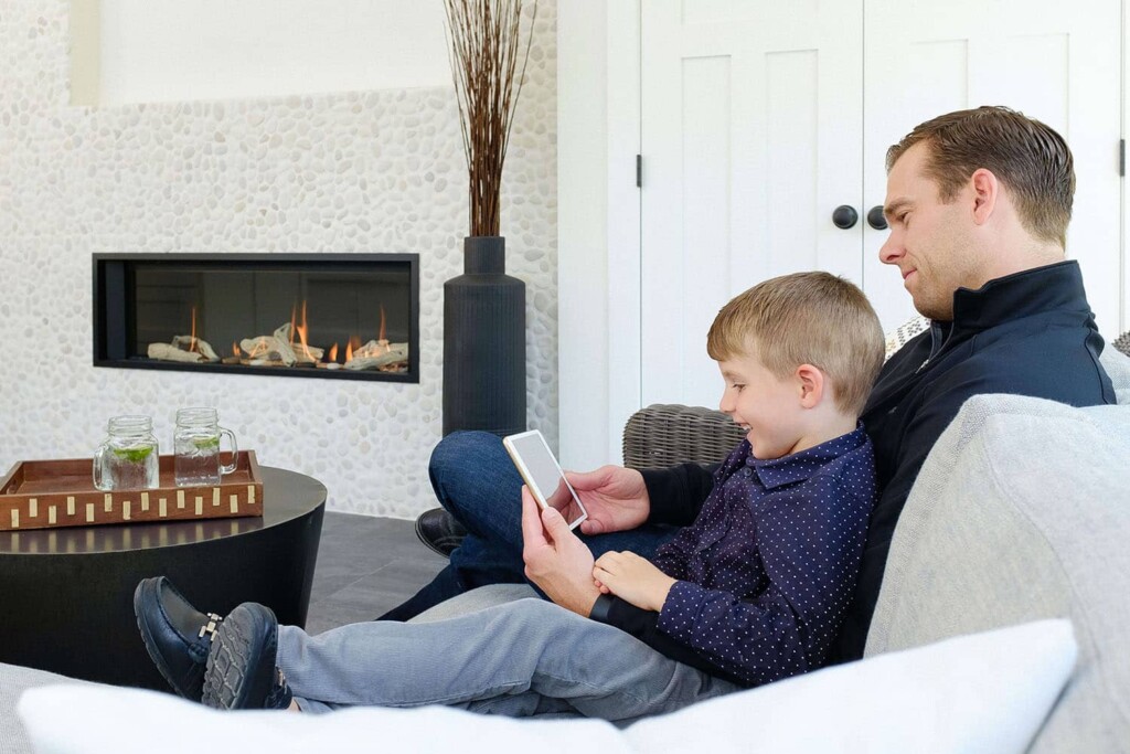 Dad and son sitting by gas fireplace