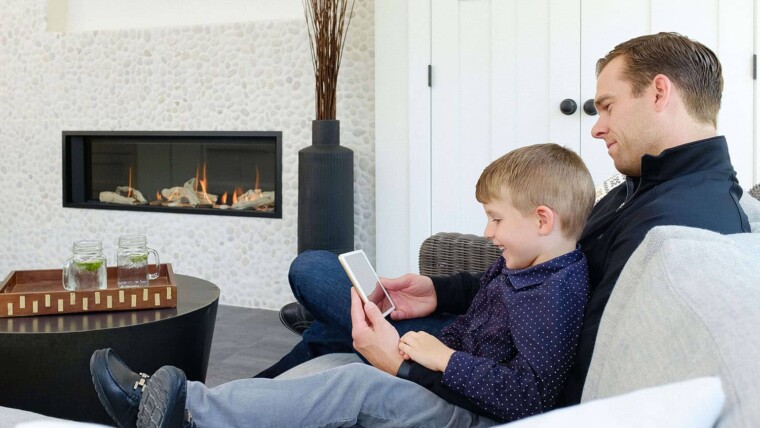 Dad and son sitting by gas fireplace